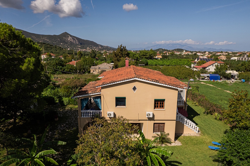 Rear exterior view of Selini Villa in Kalithea with garden and countryside