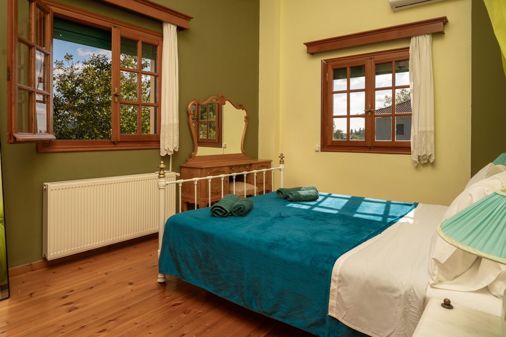 Bedroom with garden view and wooden floor at Selini Villa in Kalithea