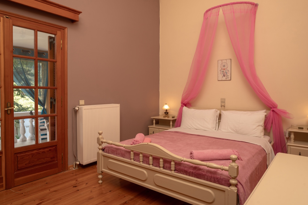 Bedroom with double bed and balcony access at Selini Villa in Kalithea