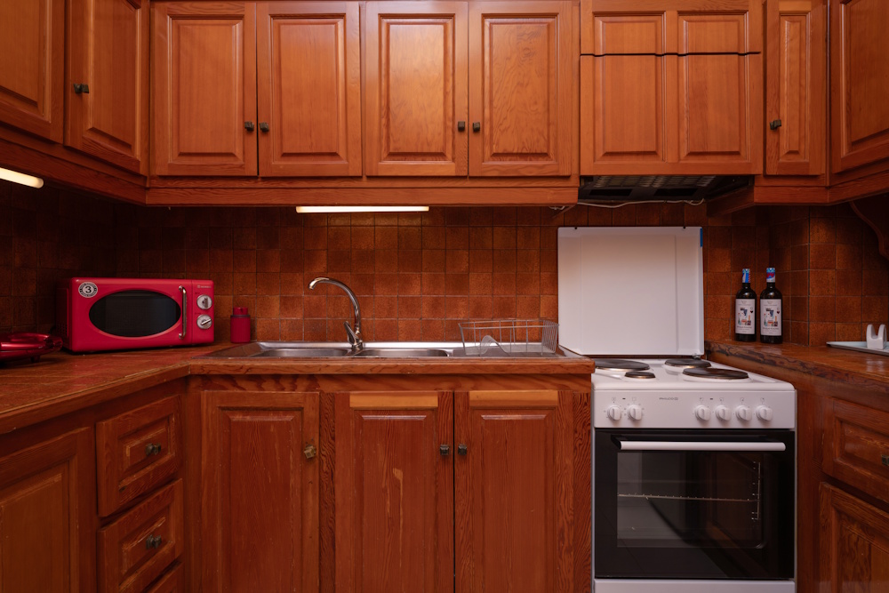 Kitchen interior with oven and wooden cabinets at Selini Villa in Kalithea