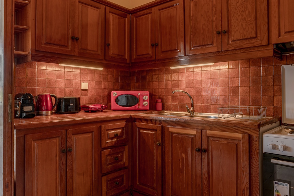 Fully equipped kitchen with wooden cabinets at Selini Villa in Kalithea