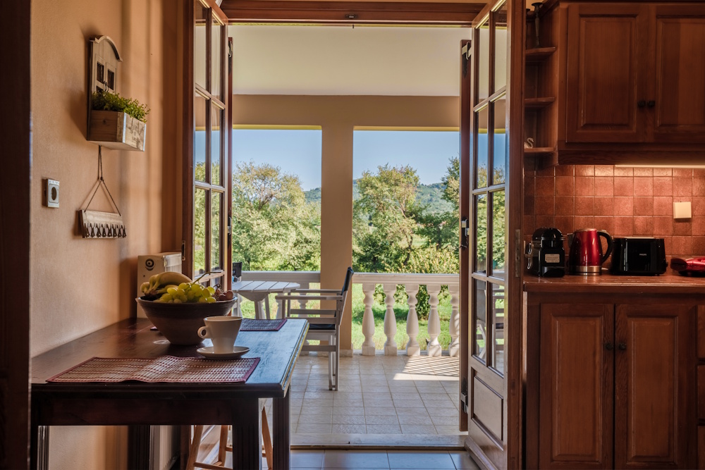 Interior dining area with open balcony doors at Selini Villa in Kalithea