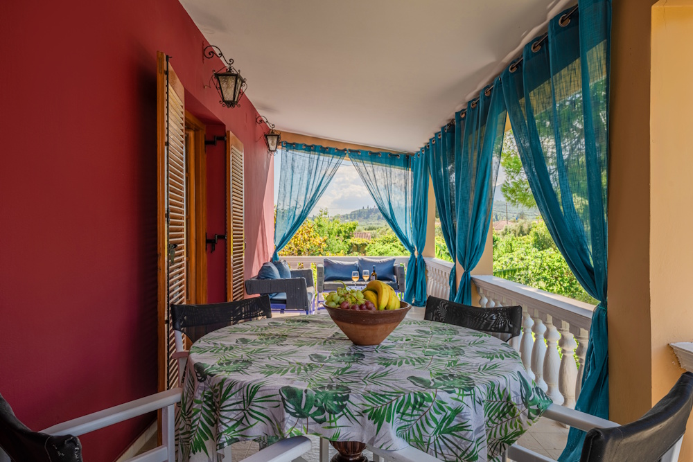 Covered balcony with outdoor dining area at Selini Villa in Kalithea