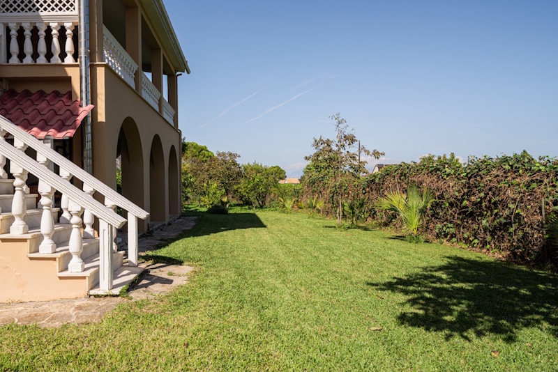Side garden view of Selini Villa in Kalithea with lawn and outdoor space