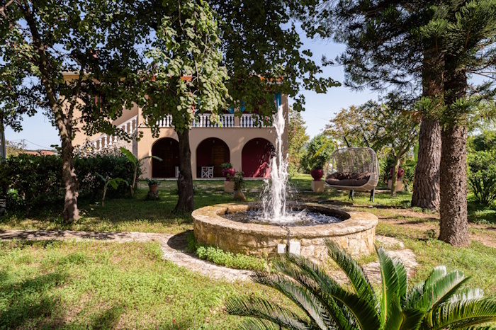 Garden fountain and outdoor seating area at Selini Villa in Kalithea