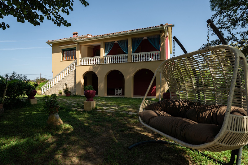 Garden view of Selini Villa in Kalithea with hanging chair and outdoor space