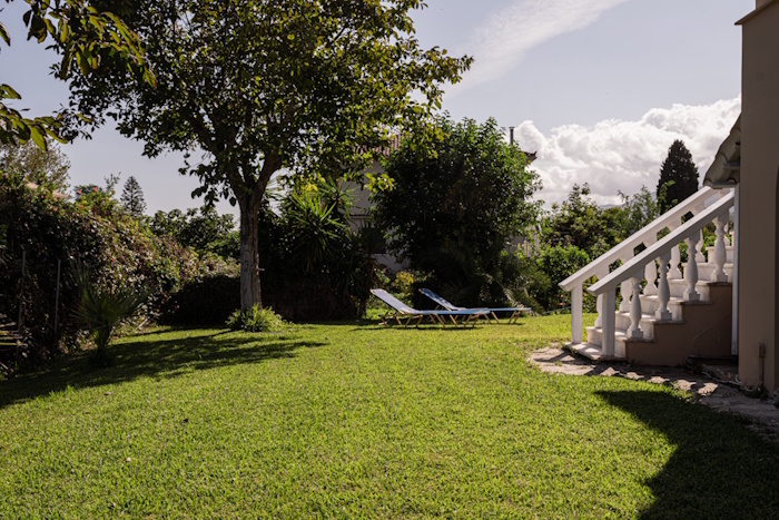 Garden view of Selini Villa in Kalithea with lawn and sun loungers